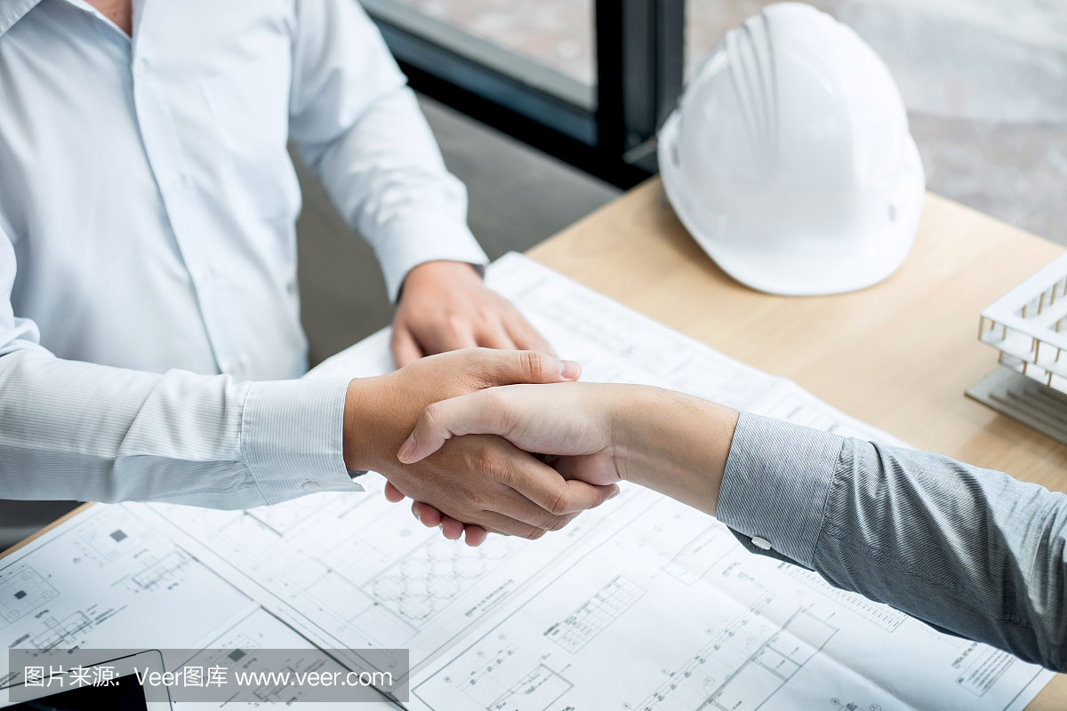 合作伙伴握手,建筑工程或建筑師討論藍(lán)圖和建筑模型,同時(shí)檢查草圖信息,為建筑項(xiàng)目的合作伙伴舉行會議